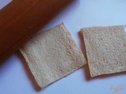 При помощи скалки хорошо раскатываем кусочки хлеба и деалем их плоскими.