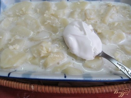 Выгрузить картофель в форму, посыпать чесноком и добавить сметану.