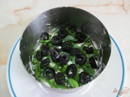 Зеленый лук мелко нарезать и выложить в кольцо. Оливки разрезать маленькими колечками и разложить аккуратно на салат.