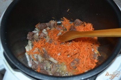 К мясу добавить морковь и лук. Жарить еще несколько минут.