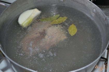 В кипящую воду опустить куриные спинки, четверть луковицы, лавровый лист и слегка подсолить. Довести до кипения и снять пену. Варить 25 минут.