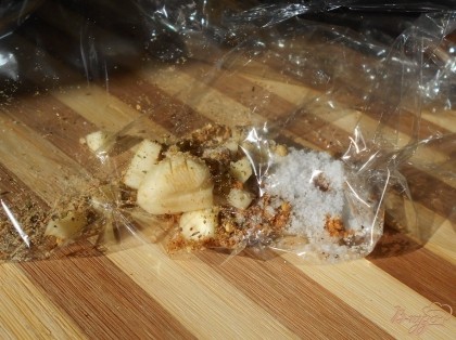 В пакет для запекания выкладываем нарезанный мелко чеснок, террагон, приправу для барбекю и соль.