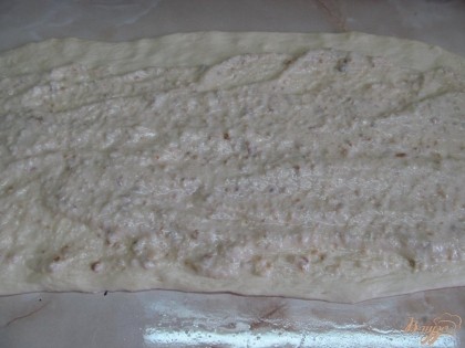 Вынимаем из миски. Нужно тесто обмять. Стол смазать растительным маслом и раскатать тесто в форму прямоугольника. Выложить начинку.
