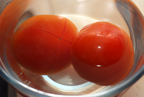 На помидорах сделайте крестообразный надрез и опустите в кипяток на пару минут, затем снимите кожицу.