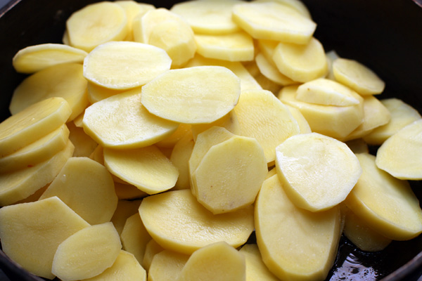 Картошку очистите и нарежьте ломтиками толщиной 0,5 см, посолите и обжарьте до полуготовности.