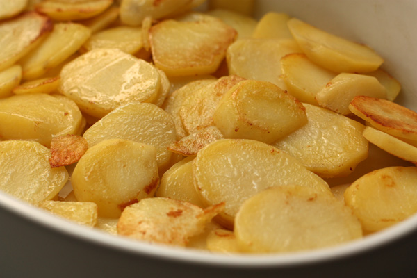 В форму для запекания равномерно выложите слой картофеля.