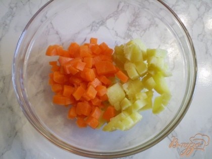Берем глубокую тару, складывает порезанный картофель и морковочку.