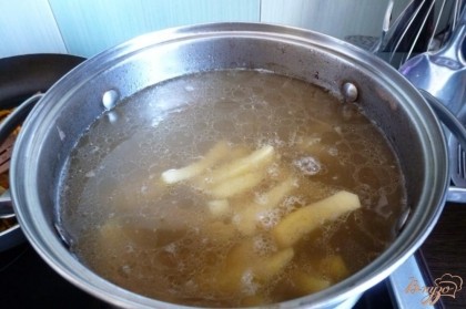 Перловка почти сварилась и мы кладем в суп картофель.Когда закипит,пусть варится минут 10.