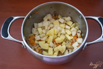 Добавляем шампиньоны. Тушим все вместе. Добавляем картофель. Обжариваем его с овощами 5 минут.