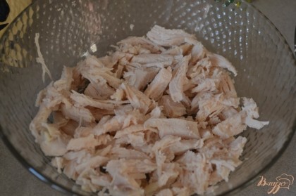 Куриную грудку отварить в подсоленной воде, остудить и порезать крупными перьями. Выложить на дно салатника.