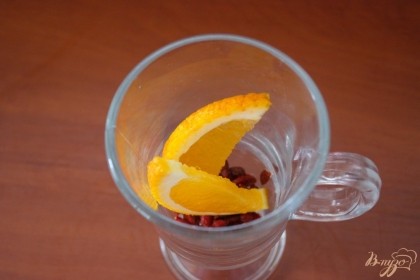 В чашку к ягодам добавляем несколько долек апельсина.