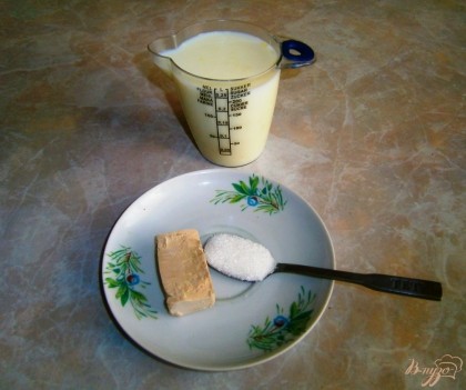 В теплом молоке развести дрожжи и 3 столовые ложки сахара.
