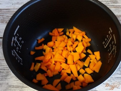 Тыкву режем кубиками, предварительно счистив с нее кожуру. Выкладываем кубики оранжевого овоща в мультиварочную чашу.