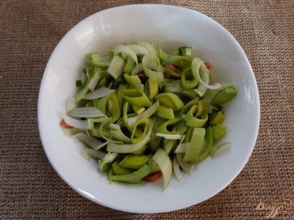 Следующий ингредиент – лук-порей. Порежьте его кольцами и выложите в салат.