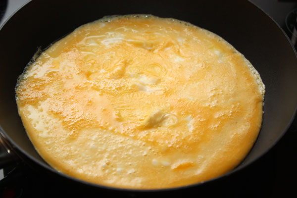 Яйца взболтайте вилкой, посолите и поджарьте на сковороде в виде блина толщиной около 5 мм. Остудите и нарежьте квадратиками.