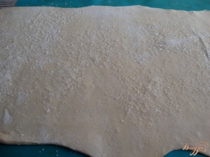 Слоеное тесто оставляем размораживаться. Когда тесто полностью разморозится, раскатываем его на столе, слегка пройдемся по нему скалкой и посыплем сахаром.