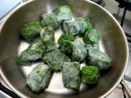 Мороженые кубики шпината отправляем на сковороду с растительным маслом. Когда кубики оттают, добавим к ним соль и чеснок выдавленный через пресс.