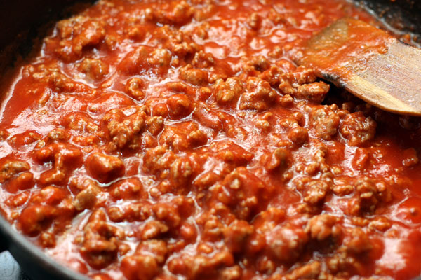 Влейте в мясо бульон, положите томатное пюре или мелко нарезанные и очищенные от кожицы помидоры. 