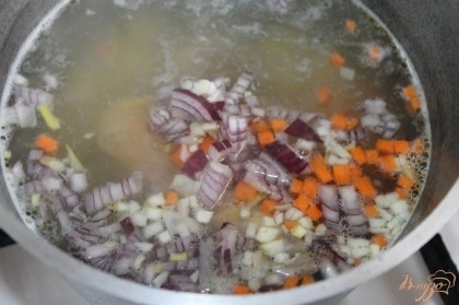 Добавить овощи в суп и варить на медленном огне.