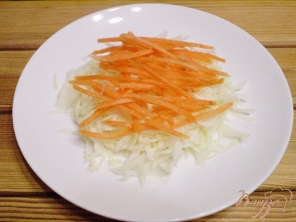 С помощью крупной терки натрите морковь. Уложите на капусту. Посолите.