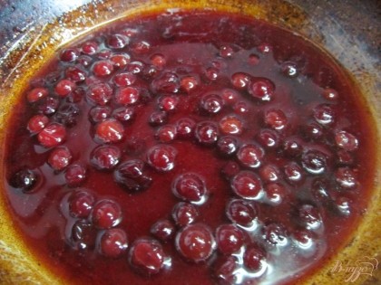 В сковороду высыпать ягоды, добавить сахар, воду и вино. Довести до кипения и уварить наполовину.