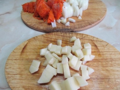 Картофель нарезать удобными для вас кусочками и отправить в бульон. Картофель будет вариться минут 15. Тем временем морковь натереть на терке, а лук мелко нарезать.