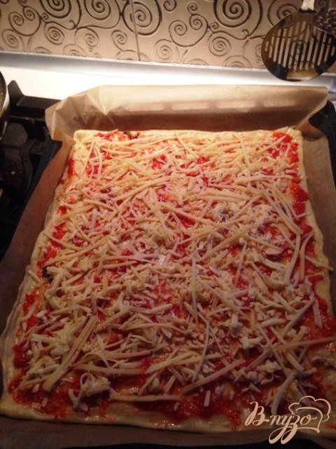 Раскатываем тонко дрожжевое тесто, смазываем томатным соусом  и посыпаем специями для пиццы. Посыпаем тертым сыром. Тесто готовим по рецепту http://vpuzo.com/vypechka/6374-universalnoe-drozhzhevoe-testo.html