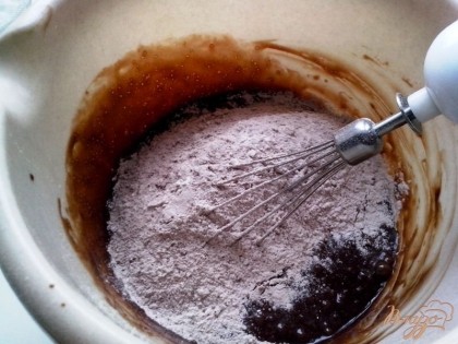 Соединить немного остуженную шоколадно-маслянную смесь и яйца с сахаром. Перемешать, ввести сухую смесь.