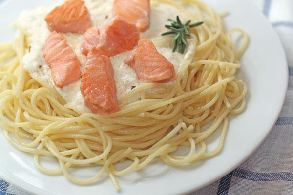 Спагетти выложите на тарелки, сверху полейте соусом и выложите кусочки рыбы.