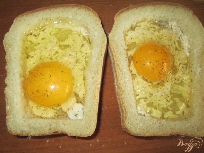 Положите корочки на целые кусочки хлеба. Внутрь в каждый бутерброд вбейте по одному яйцу, постарайтесь, чтобы желток остался целым. Посолите, поперчите по вкусу. Выложите на противень.