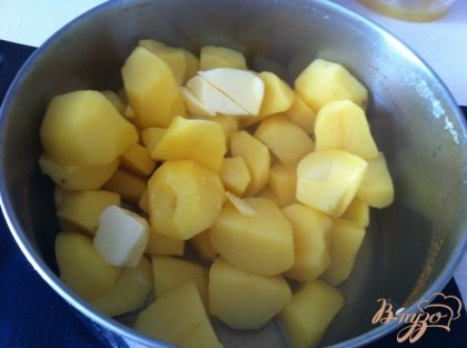 Сливаем готовый картофель, добавляе масло и разминаем.