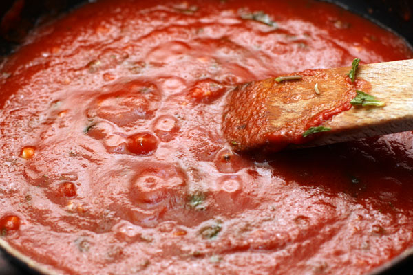 Для соуса возьмите томатное пюре (или измельчите в блендере очищенные спелые помидоры) и уварите его наполовину, добавив оливковое масло и измельченный базилик.