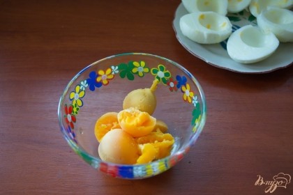 Отварные яйца очистить от скорлупок. Каждое разрезать пополам. Вынуть желток. Желтки поместите в миску.