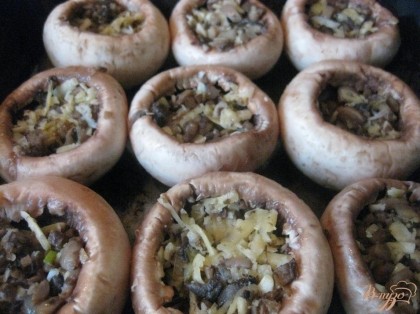 В шляпки грибов выложить смесь фарша – жареные грибы с луком и сыр.