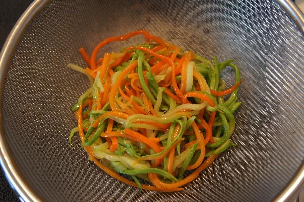 Вынуть готовые овощи в сито, чтобы стекло все масло.