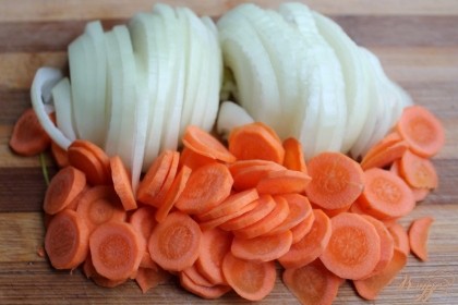 Далее, нарезаем лук и морковь и добавляем к мясу. Наливаем 100 мл. кипятка и готовим минут 20.