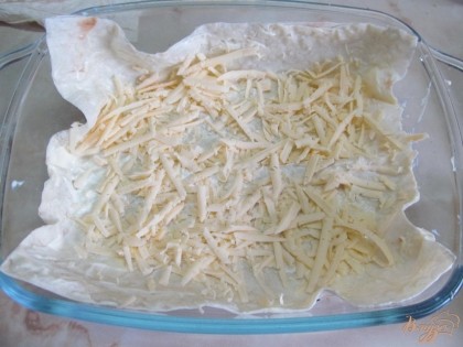 Выложить первый пласт. Майонез смешать со сметаной и смазать лаваш (смазки много наносить не нужно). Сверху натереть сыр на крупной терке.