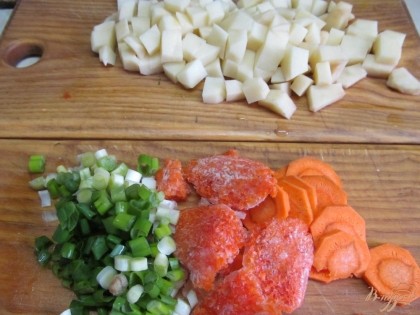Нарезать картофель удобными для вас кусочками. Часть моркови натереть на терке и остальную нарезать кружочками. Нарезать зеленый лук. И зразу все овощи выгрузить в кастрюлю с бульоном. Варить минут 15 до готовности картофеля.
