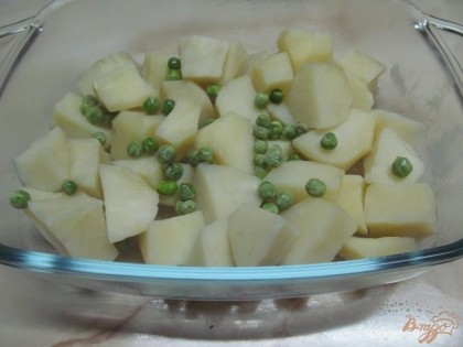 В форму выложить картофель без жидкости и посыпать горошком.