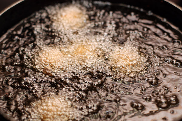 Когда масло хорошо нагреется, опускайте туда шарики с помощью шумовки и готовьте около 2 минут, пока они не станут золотисто-коричневыми.