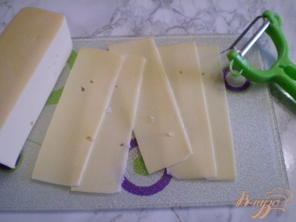 Сыр нарезать можно тонко с помощью специального ножа для сыра, или воспользуйтесь овощечисткой. Она нарезает тонко-тонко и красиво. Также несколько полочек нужно разрезать вдоль на половинки для будущего украшения.