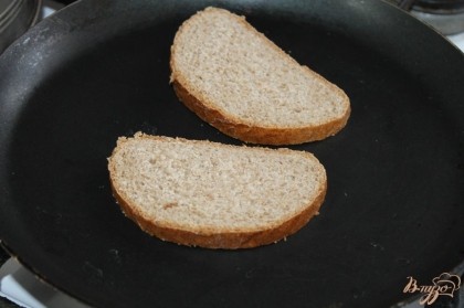 На сухой сковороде подсушить хлеб. Натереть его чесноком.
