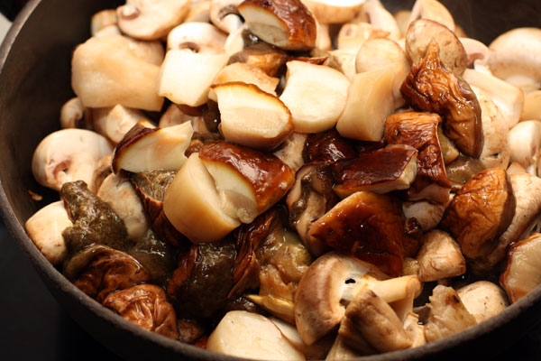 Добавьте промытые, очищенные и нарезанные белые грибы.