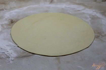 Раскатать тесто и обрезать с помощью круглой доски заготовку.