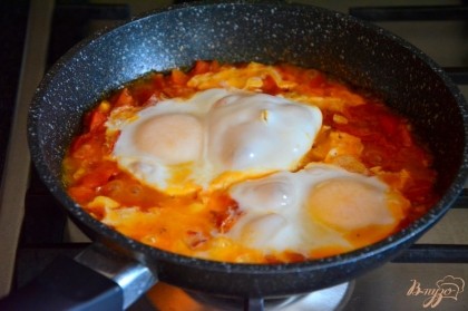 Дать покипеть смеси минут 5, затем сделать лопаткой небольшие углубления и вбить туда сырые яйца, посолить по вкусу.