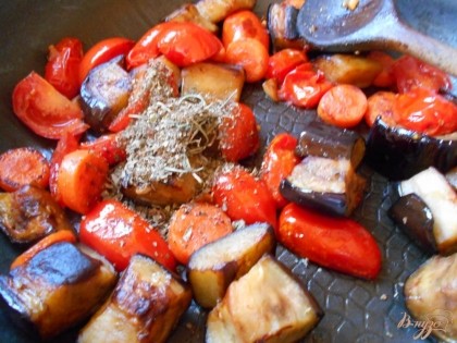 Когда баклажаны уже поджарились, снижаем огонь до минимального, добавляем помидоры черри, солим и перчим гарнир. Протушиваем гарнир под крышкой до мягкости помидоров.