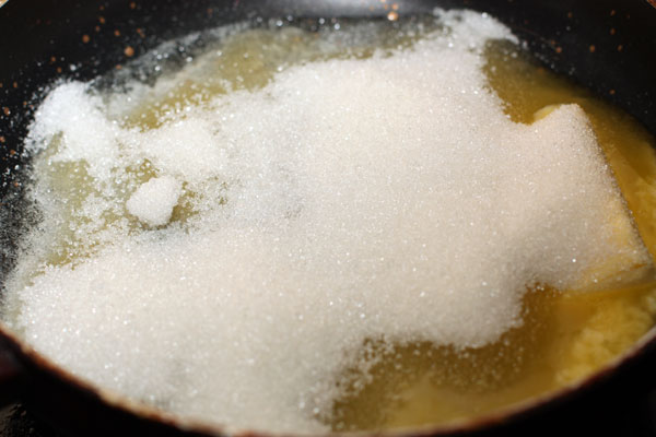 Для начинки растопите сливочное масло на сковороде, добавьте сахар и доведите до однородной консистенции.