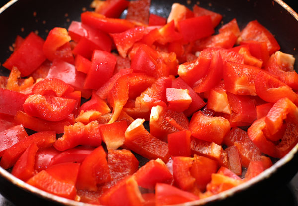 Перец очистите от семян, нарежьте некрупными кусочками и положите на сковороду, в которой жарилось мясо. Добавьте молотую паприку.