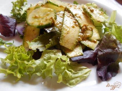 На блюдо выкладываем листья салата. Сверху выкладываем промаринованные огурцы с цуккини и соусом песто.