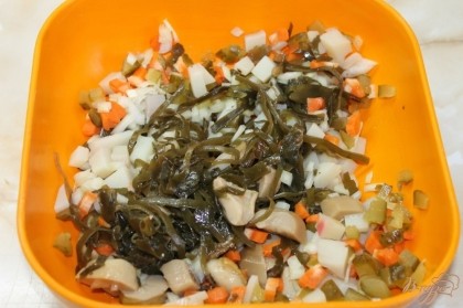 В глубокой миске соединить нарезанные овощи, морскую капусту и грибы белые маринованные.